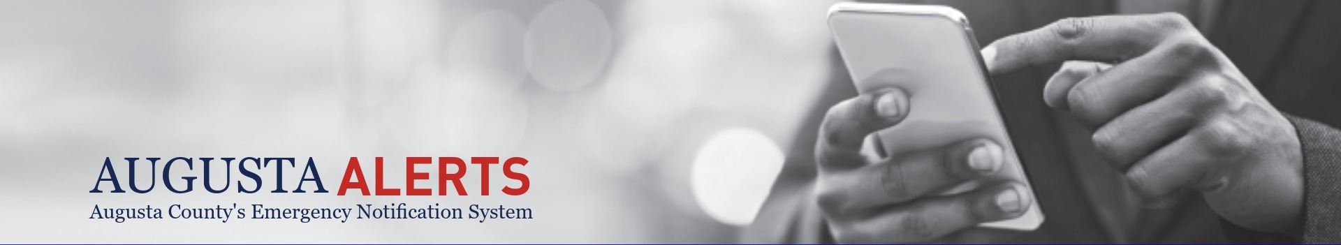 black /white image of hands navigating on phone with Augusta Alerts logo