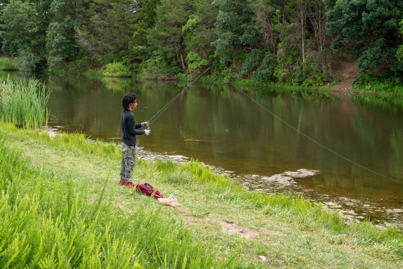 One person fishing at the Trails at Mill Place Park.